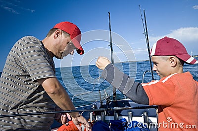 Father and son fishing at sea Stock Photo