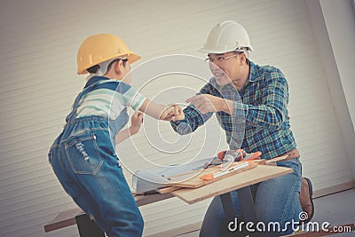 Father and Son fist bump for success concept in construction industry concept in vintage tone, Daddy and kid hand together for Stock Photo