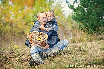 Father and son with full basket of mashrooms on the forest glade Stock Photo