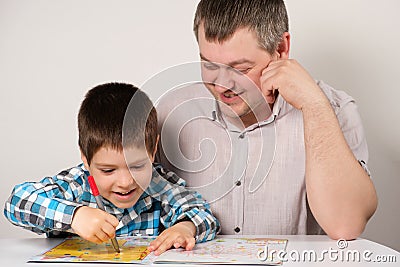 Father and son go through labyrinths, perform tasks for logic and the development of thinking in preparation for school. Stock Photo