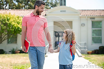 Father and son go to school, education and learning. Parent and pupil of primary school schoolboy with backpack. Stock Photo