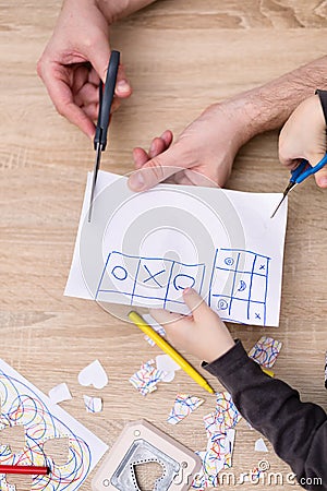 Father and son hands cutting paper with scisors Stock Photo