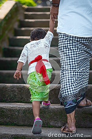 Father and son hold hands and climb the stairs. Indonesian culture. Island of Bali. Close up Editorial Stock Photo