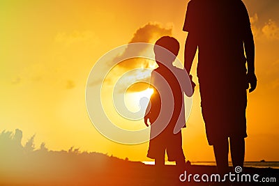 Father and son holding hands at sunset sea Stock Photo