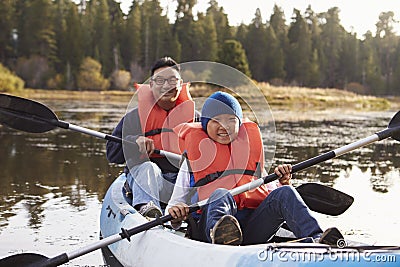 Father and son kayaking on a rural lake, front view Stock Photo