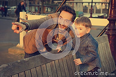 Father and son looking at the sunset together. Stock Photo