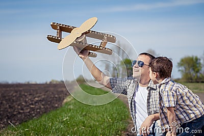 Father and son playing with cardboard toy airplane in the park a Stock Photo