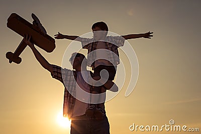 Father and son playing with cardboard toy airplane in the park a Stock Photo