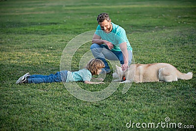 Father and son playing with dog in park. Childhood and parenthood kids concept. Happy father and son playing together Stock Photo