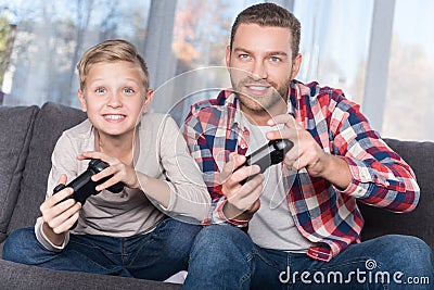 Father and son playing with joysticks Stock Photo