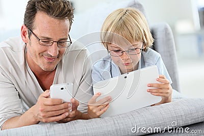 Father and son playing with smartphone and tablet Stock Photo