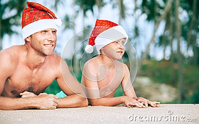 Father and son in Sants hats portrait on tropical bisland beach Stock Photo