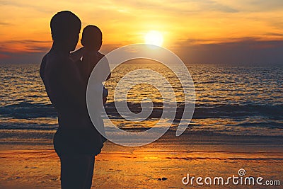 Father and son on the shore of the azure sea watching for sunset. Lifestyle, vacation, happiness, joy concept. Leisure activities. Stock Photo