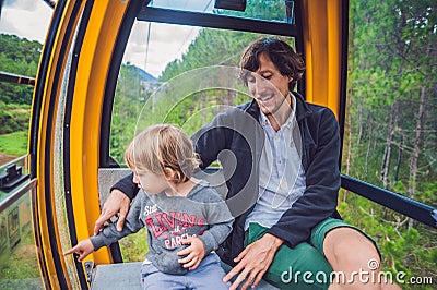 Father and son in ski lift cabin in summer. Passengers on a cable car Stock Photo