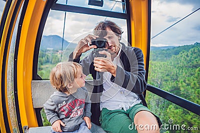 Father and son in ski lift cabin in summer. Passengers on a cable car Stock Photo