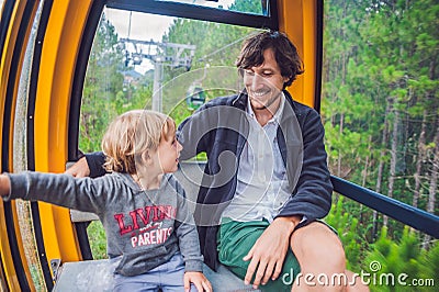 Father and son in ski lift cabin in summer. Passengers on a cable car Stock Photo