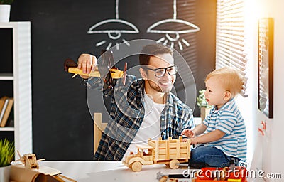 Father and son toddler gather craft a car out of wood and play Stock Photo