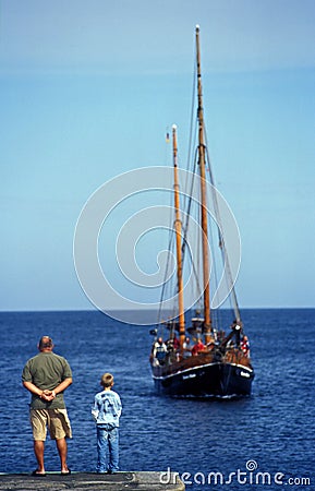 Father and son waiting for a boat in Svaneke harbor on Bornholm island Editorial Stock Photo