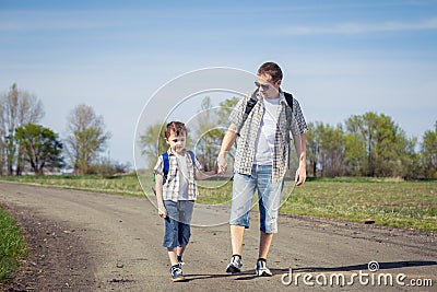 Father and son walking on the road at the day time. Stock Photo