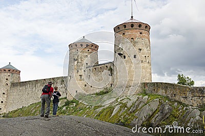 Father and son watching and taking a picture of olavinlinna castle Editorial Stock Photo