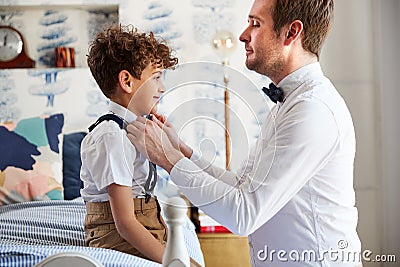 Father And Son Wearing Matching Outfits Getting Ready For Wedding At Home Stock Photo