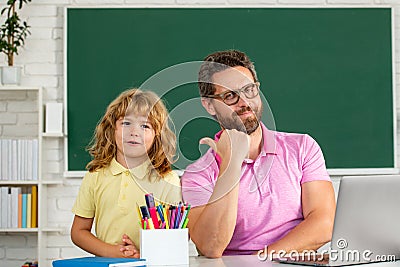 Father teacher helping a son boy in school lessons. Education and knowledge. Stock Photo