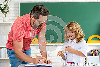 Father teacher helping a son boy in school lessons. Funny happy elementary school boy. Stock Photo