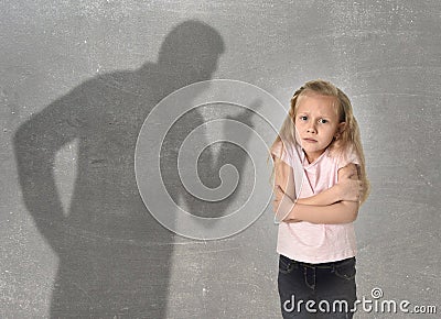 Father or teacher shadow screaming angry reproving young sweet little schoolgirl or daughter Stock Photo