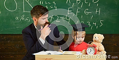 Father teaches son, discuss, explain. Kid studying with teacher. Elementary education. Teacher in formal wear and pupil Stock Photo