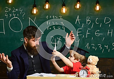 Father teaches son elementary knowledge, discuss, explain. Grade school concept. Kid studies with teacher, listening Stock Photo