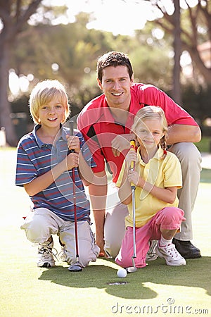 Father Teaching Children To Play Golf Stock Photo