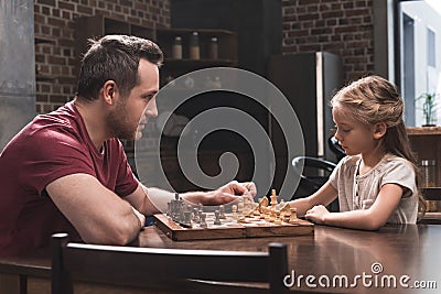 Father teaching daughter to play chess Stock Photo