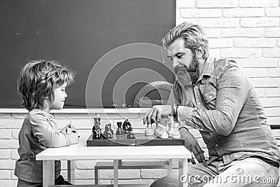 Father teaching his son to play chess. Chess strategy. Chess success and winning. Education and people concept. Happy Stock Photo