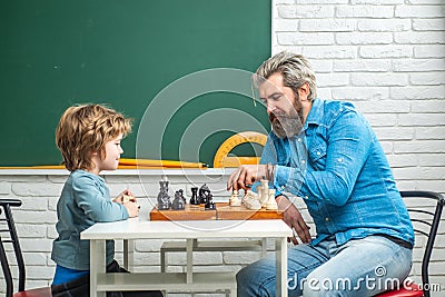 Father teaching his son to play chess. Chess strategy. Chess success and winning. Education and people concept. Happy Stock Photo