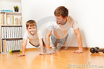 Father teaching kid son doing push-ups exercises Stock Photo