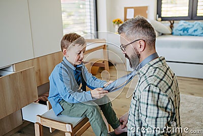 Father teaching son how to tie a tie. Memorable moment for young boy. Stock Photo