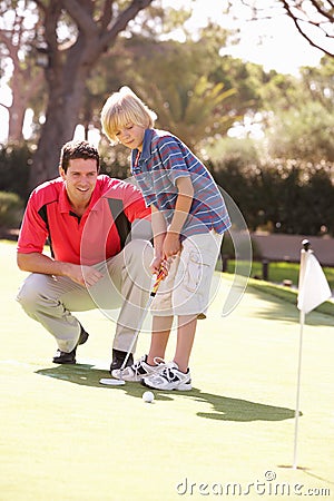 Father Teaching Son To Play Golf Stock Photo