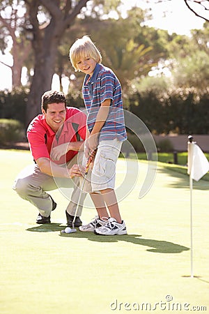 Father Teaching Son To Play Golf Stock Photo