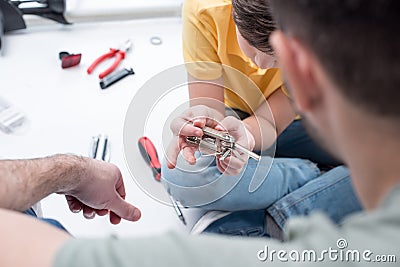 Father teaching son to use bicycle multi tool on white Stock Photo