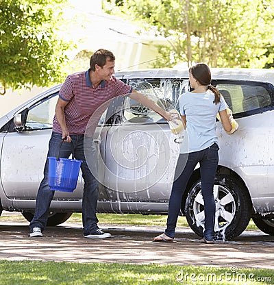 Father And Teenage Daughter Washing Car Together Stock Photo