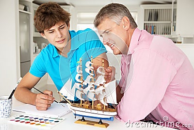 Father and teenage son model making and painting Stock Photo