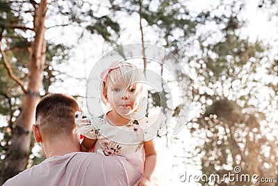 Father throws baby in nature, girl flies in the sky. Portrait dad with child together. Daddy, little daughter outdoors Stock Photo