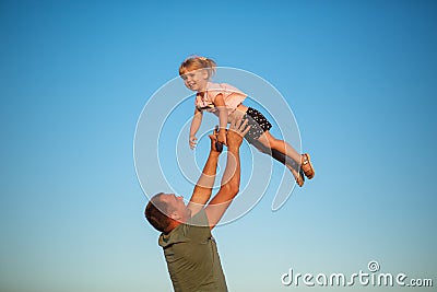 Father throws daughter up in his arms Stock Photo