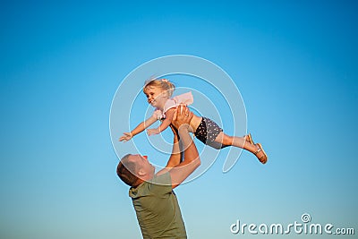 Father throws daughter up in his arms Stock Photo