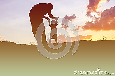 Father took the baby learn to walk at sunset Stock Photo