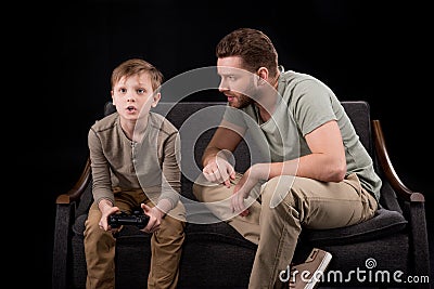 Father trying to talk with little son playing with joystick Stock Photo