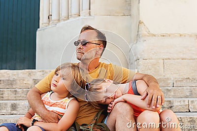 Father with two tired kids resting outside Stock Photo