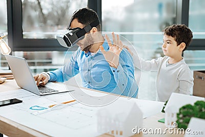 Father in VR headset asking son not to distract him Stock Photo