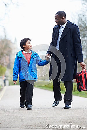 Father Walking Son To School Along Path Stock Photo