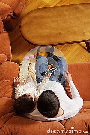 Father watching television with daughter Stock Photo